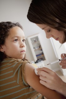 Girl (8-9) having vaccination. 
Photo : Rob Lewine