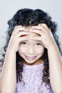 Portrait of smiling girl (8-9), studio shot. 
Photo : Rob Lewine