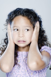Girl (8-9) covering her ears, studio shot. 
Photo : Rob Lewine