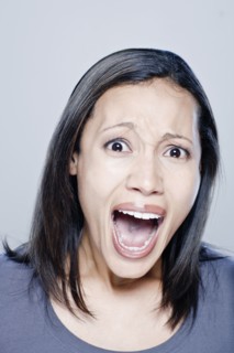 Portrait of screaming young woman, studio shot. 
Photo : Rob Lewine