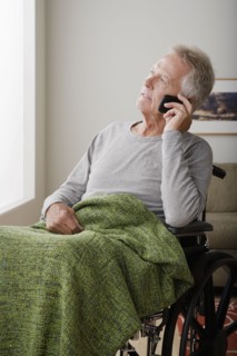 Senior man on wheelchair talking via mobile. 
Photo : Rob Lewine