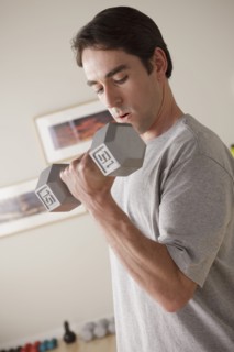 Young man exercising with dumbbell. 
Photo : Rob Lewine