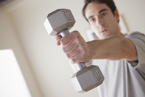 Young man exercising with dumbbell. 
Photo : Rob Lewine
