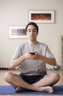 Young man meditating with mobile. 
Photo : Rob Lewine