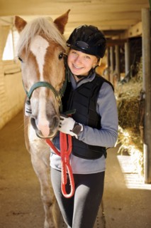 Portrait of teenage girl (16-17) with horse in stable. 
Photo : Elena Elisseeva