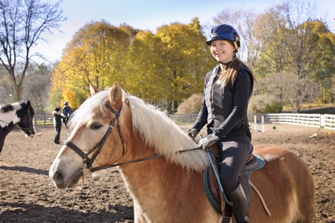 Canada, Ontario, Toronto, Portrait of teenage girl (16-17) riding on horse. 
Photo: Elena