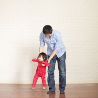 Father helping baby girl (12-17 months) with her first steps. 
Photo: Jessica Peterson
