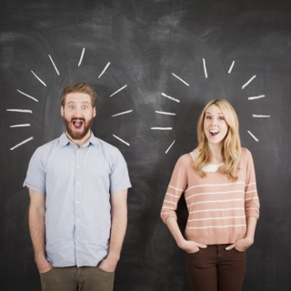 Young couple with blackboard in background, studio shot. 
Photo : Jessica Peterson