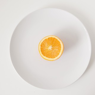 Half of orange on plate, studio shot. 
Photo: Jessica Peterson