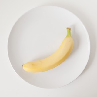 Banana on plate, studio shot. 
Photo: Jessica Peterson