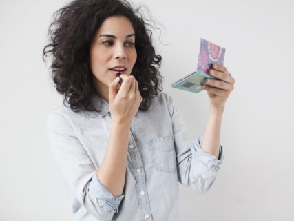 Beautiful young woman applying lipstick. 
Photo: Jessica Peterson