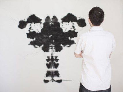Man looking at black complex shape painted on wall. 
Photo : Jessica Peterson