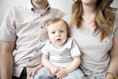 Young couple with baby boy (6-11 months) sitting on sofa. 
Photo: Jessica Peterson