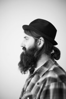 Profile of male character wearing long beard, hat and lumberjack shirt. 
Photo : Jessica Peterson