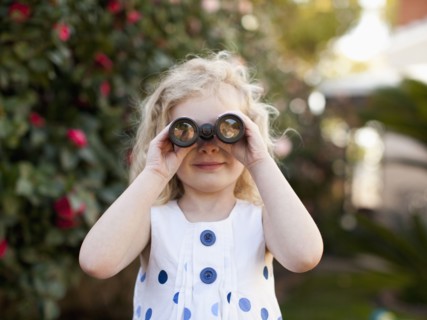 Young girl (4-5) looking through binoculars. 
Photo : Jessica Peterson