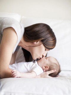 Mother kissing baby girl (2-5 months). 
Photo : Jessica Peterson