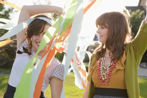 Two happy female friends playing in domestic garden. 
Photo : Jessica Peterson