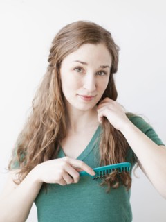 Attractive young woman combing hair. 
Photo: Jessica Peterson
