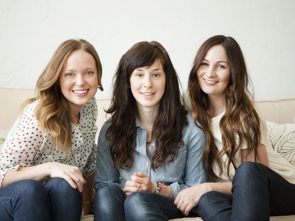 Three young female friends sitting on sofa. 
Photo : Jessica Peterson