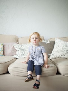 Toddler girl (2-3) sitting on sofa. 
Photo: Jessica Peterson