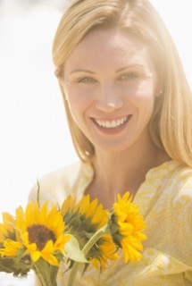 Woman holding sunflowers.