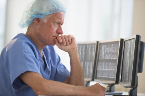 Senior surgeon working on computer.