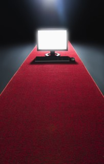 Studio shot of glowing computer on red carpet.