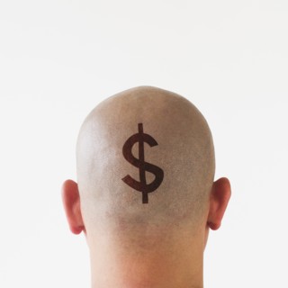 Back view of man with dollar sign on shaved head.