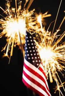 Sparkler and American flag an black background.