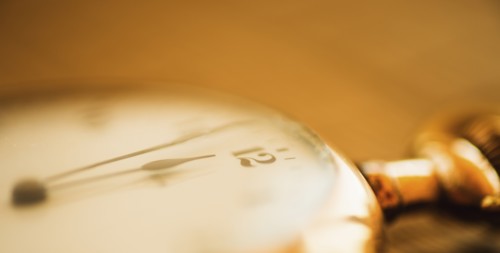 Close-up shot of pocket watch in yellow monochrome.