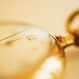 Close-up shot of pocket watch in yellow monochrome.
