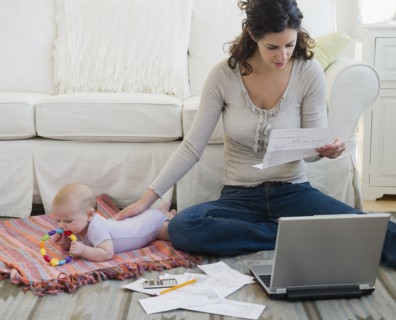 Mother with baby boy (2-5 months) sorting home finances. Photo : Jamie Grill
