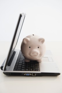 Piggybank sitting in open laptop. Photo: Jamie Grill