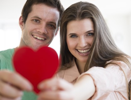 Young couple showing red heart. Photo : Jamie Grill