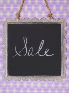 Studio shot of small blackboard with word Sale. Photo : Daniel Grill
