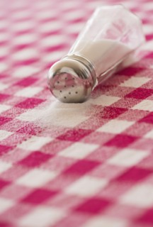 Salt shaker on checked tablecloth. Photo : Daniel Grill