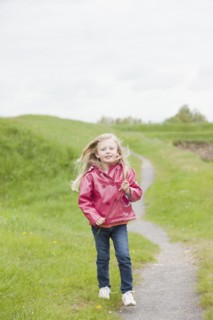 Girl in pink raincoat on country path. Photo : Mike Kemp
