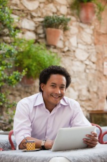 France, Cassis, Man using digital tablet in cafe. Photo: Mike Kemp