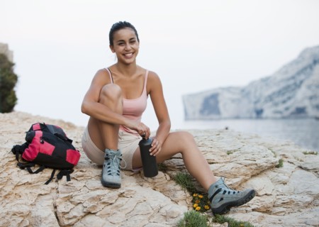 France, Marseille, Female hiker resting on rocky beach. Photo : Mike Kemp