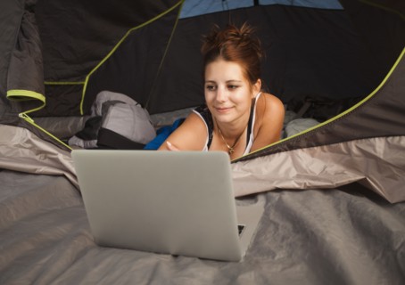 Hiker in tent using laptop. Photo : Mike Kemp