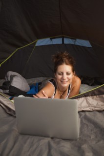 Hiker in tent using laptop. Photo : Mike Kemp