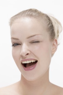 Portrait of young woman laughing and making eye. Photo : Jan Scherders