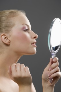 Beauty portrait of woman looking in mirror. Photo: Jan Scherders