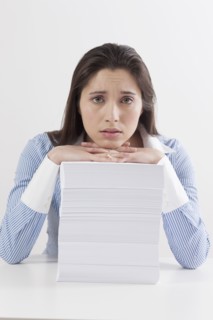Studio shot of woman with stack of documents. Photo : Jan Scherders