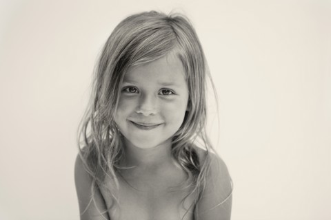 Portrait of smiling girl (6-7), studio shot. Photo: King Lawrence