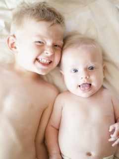 Portrait of boy (2-3) with baby sister (6-11 months). Photo: Jessica Peterson