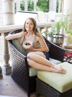 Portrait of young woman having strawberry. Photo : Jessica Peterson
