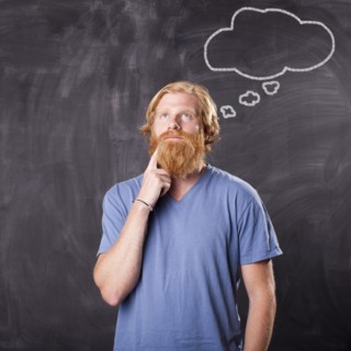 Man in front of blackboard with drawing depicting speech bubble. Photo : Jessica Peterson