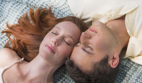 Portrait of couple lying on blanket. Photo : Tetra Images