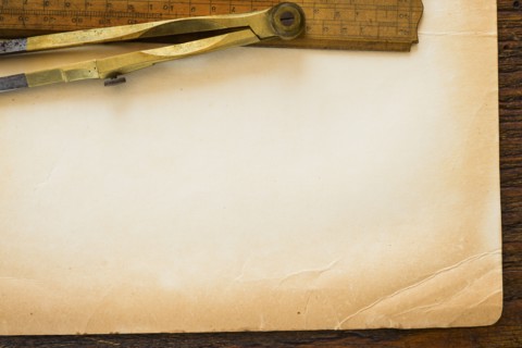 Old brown paper with ruler and compass, studio shot.